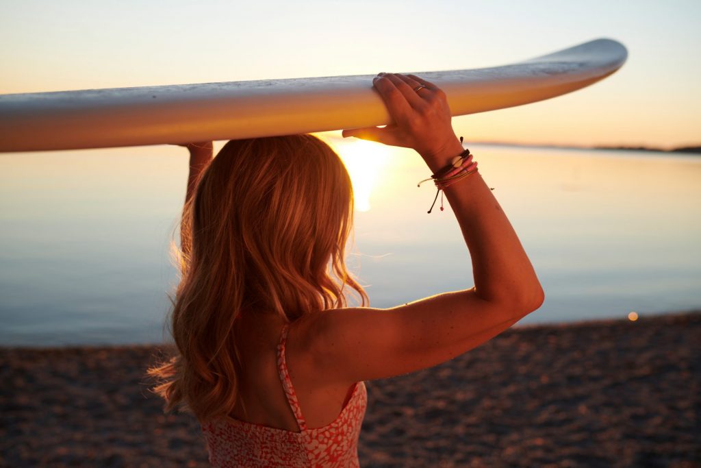 Tamara mit surfbrett am Chiemsee fuer ihren Blog